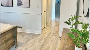 A modern interior with a wooden floor, white walls, and a hallway leading to a kitchen area. - Charming 2-bedroom house in El Centro with WiFi, AC (El Centro)