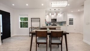 A modern kitchen with white cabinets, a central island, and pendant lighting. - Charming 3Bed 2Bath Home with WiFi & AC in enjoyable Beverlywood and BH adjacent (Los Angeles)
