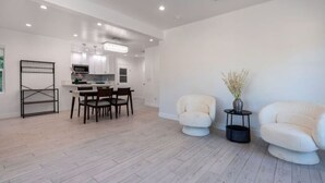 A spacious living area with a dining table and chairs, a sofa, and a small side table with a vase. - Charming 3Bed 2Bath Home with WiFi & AC in enjoyable Beverlywood and BH adjacent (Los Angeles)