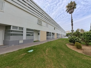 Un edificio moderno con techo plano, ventanas amplias y un paseo pavimentado.
