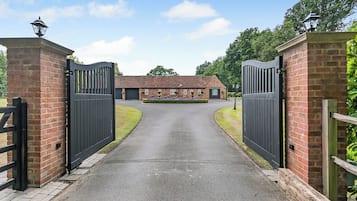 Ein begrenzter Zugangsweg führt zu einem Backsteinhaus mit Garage und kleinem Garten.
