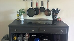 A kitchen with a black cabinet, hanging pots, and a dish rack. - Meadowlark Suite at Cooperstown Lodge 3Miles toCDP (Cooperstown)