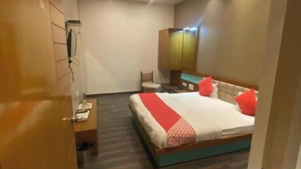 A hotel room with a bed, bedside table, and a wardrobe. - Hotel Raghupati - Ayodhya (Faizabad)