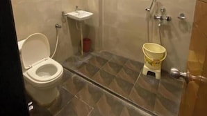 A bathroom with a toilet, sink, and shower area. - Hotel Raghupati - Ayodhya (Faizabad)