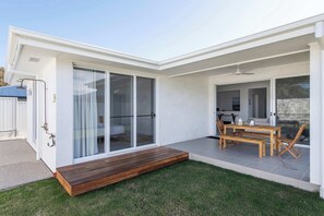 Una casa moderna con un patio, puertas corredizas de vidrio y un comedor.