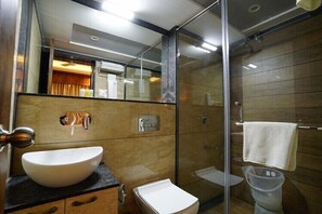 A modern bathroom with a large white sink, a small toilet, and a glass-enclosed shower area. - Mantra A Boutique Hotel (Jodhpur)