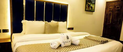 A hotel room with a large bed, a headboard with vertical panels, a wooden door, and a painting on the wall.