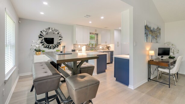 A modern kitchen with a central island, built-in appliances, and a dining area with bar stools. - 30 Miles to NRG Stadium - Family Home in Houston! (Houston)
