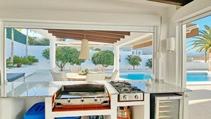 A modern kitchen with a view of a pool and outdoor seating. - Villa Esmeralda by Solidays - Moraira, Costa Blanca (Moraira)