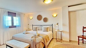 A bedroom with a bed, bedside tables, a window with curtains, a radiator, and wall-mounted lights. - Villa Esmeralda by Solidays - Moraira, Costa Blanca (Moraira)