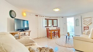 A living room with a TV, sofa, and dining area. - Villa Esmeralda by Solidays - Moraira, Costa Blanca (Moraira)