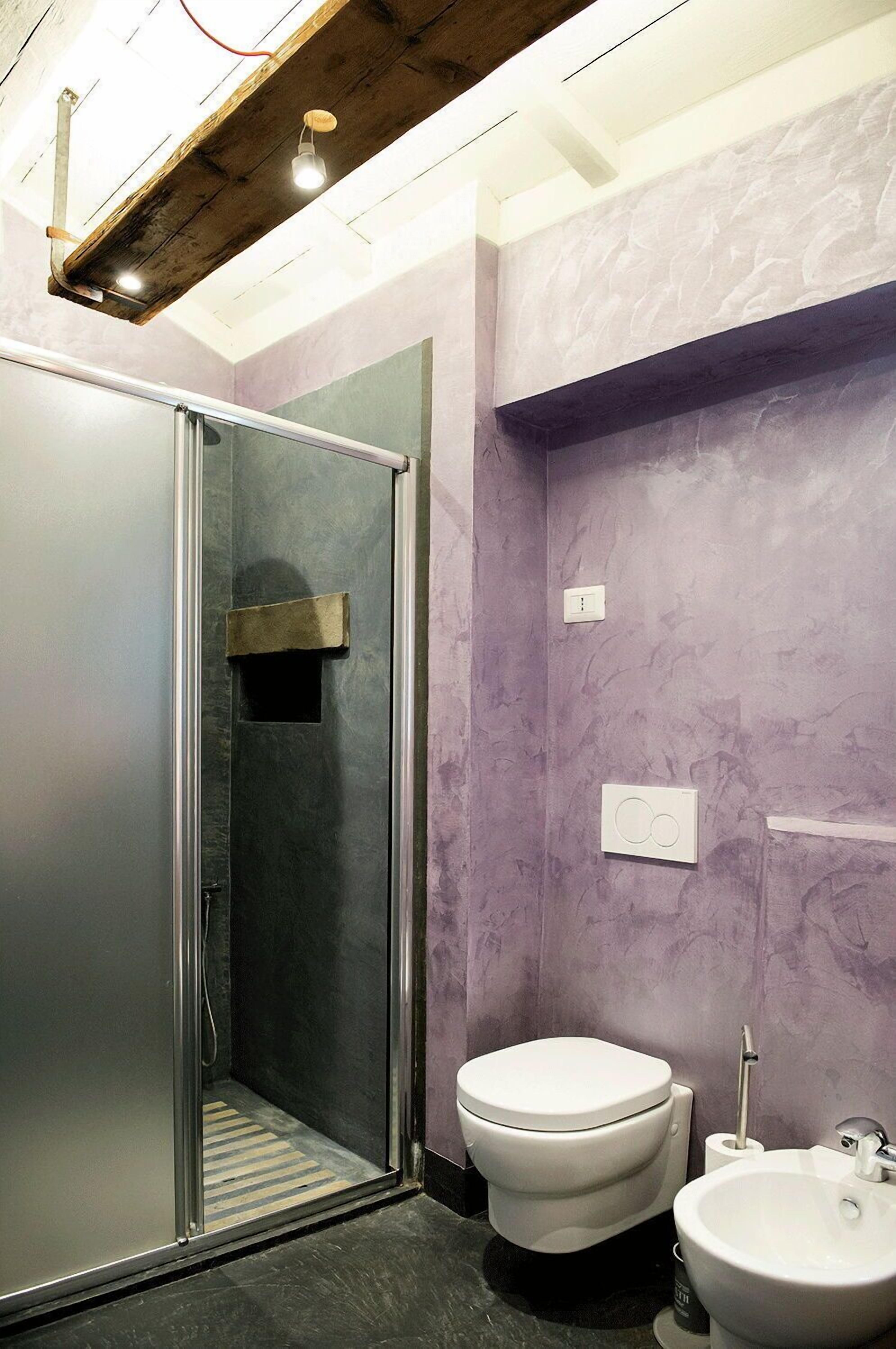 A bathroom with a glass-enclosed shower, a white toilet, and a sink.