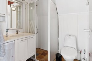 A bathroom with a sink, mirror, shower, and toilet. - Holiday Home Near Beach Fun in Gedser (Gedser)