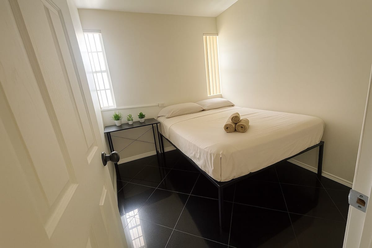 Ein Schlafzimmer mit einem Bett, einem Nachttisch und einem Fenster.