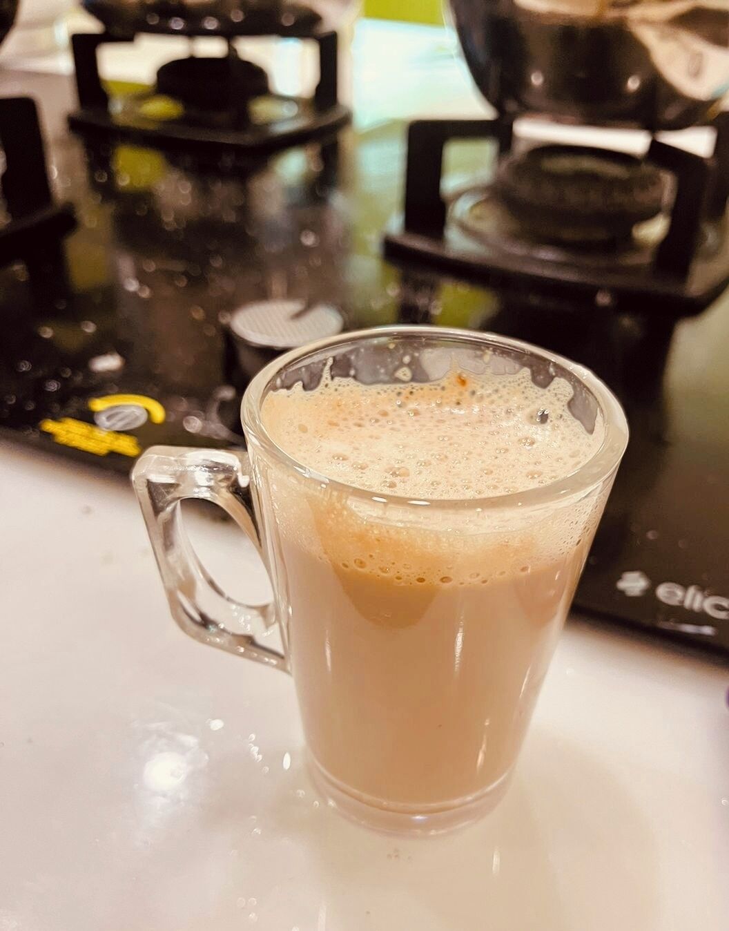 A glass mug with a beverage on a kitchen counter.