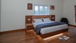 Une chambre à coucher avec un lit en bois, une table de chevet, une fenêtre et deux œuvres d’art accrochées au mur.