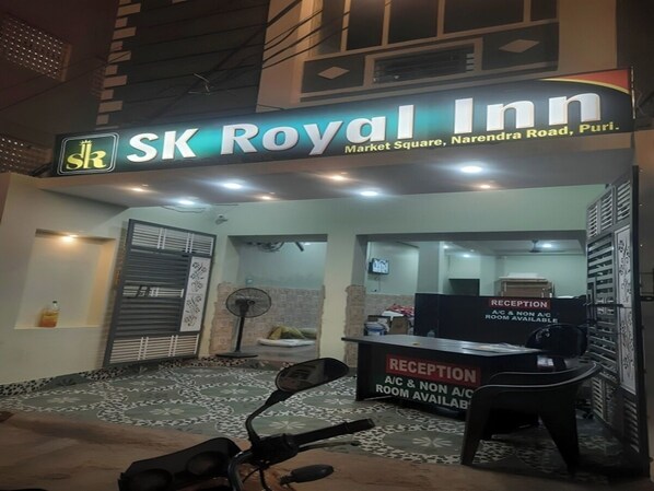 SK Royal Inns exteriör, med en receptionsdisk och en skylt som visar vilka rum som har luftkonditionering och vilka som inte har det.