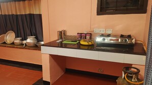 A kitchen with a gas stove, pots, and a gas cylinder.