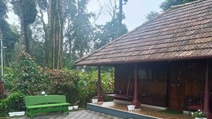 A building with a tiled roof and a checkered floor. There is a green bench and a white planter.