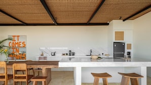 Una cocina moderna con encimera de mármol, sillas y taburetes de madera.