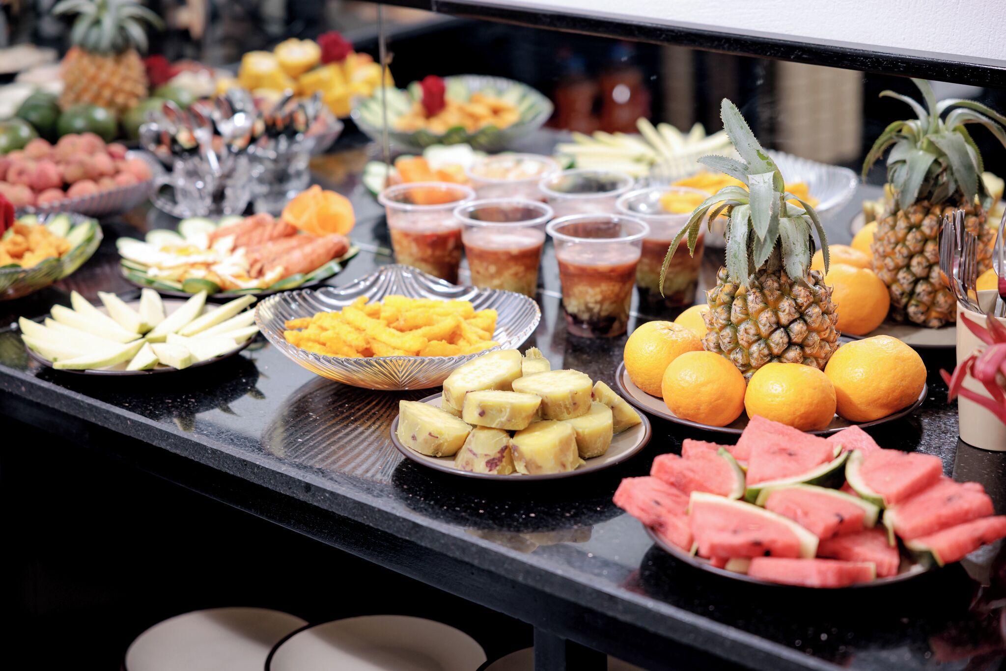 A buffet with various fruits and beverages.
