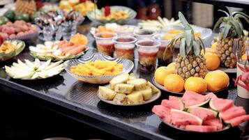 A buffet with various fruits and beverages.