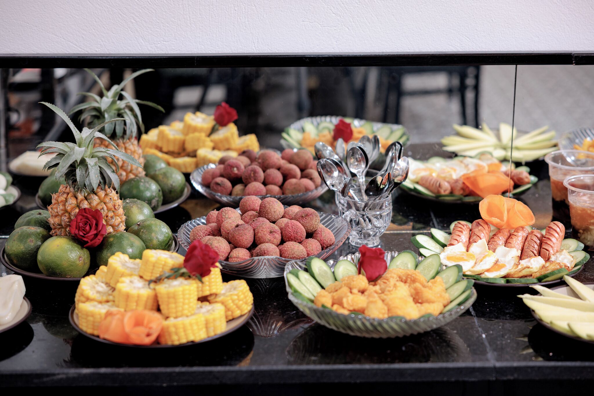 A buffet table with various dishes including fruits, vegetables, and other food items.