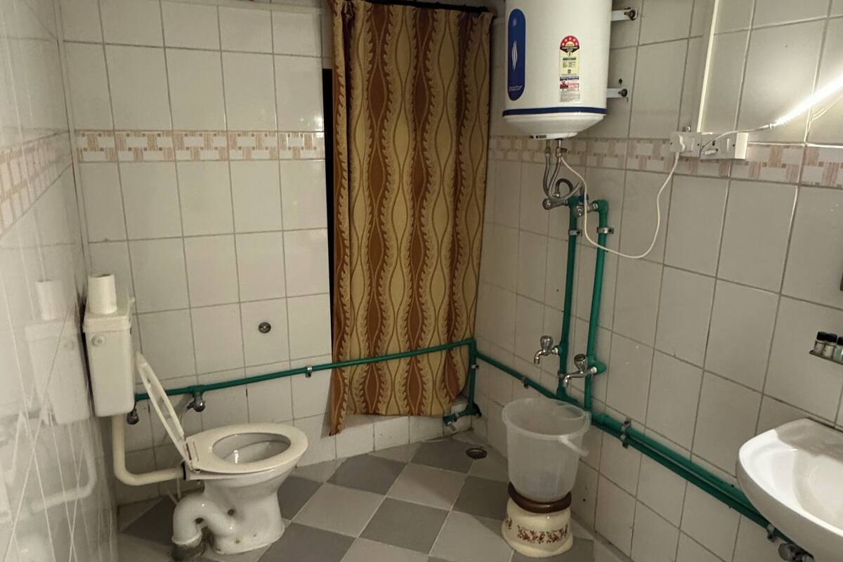 Um banheiro pequeno com vaso sanitário, pia, chuveiro e aquecedor de água.