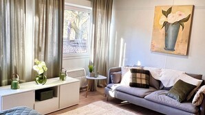 Una camera da letto moderna con un letto, un divano, una scrivania e una finestra con tende.