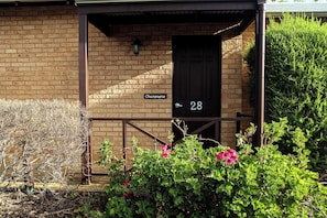 Un edificio de ladrillo con una puerta negra que lleva la leyenda 'Champagne' y el número '28'.