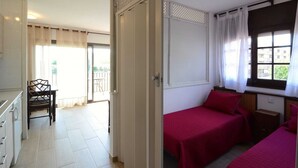A room with two beds, a dining table, and a chair. - Apartment in Estartit near golf club (Estartit)