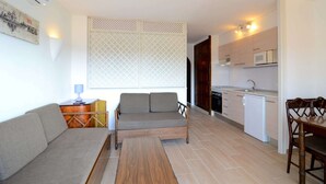 A compact living space with a sofa, a small table, a kitchenette, and a dining area. - Apartment in Estartit near golf club (Estartit)