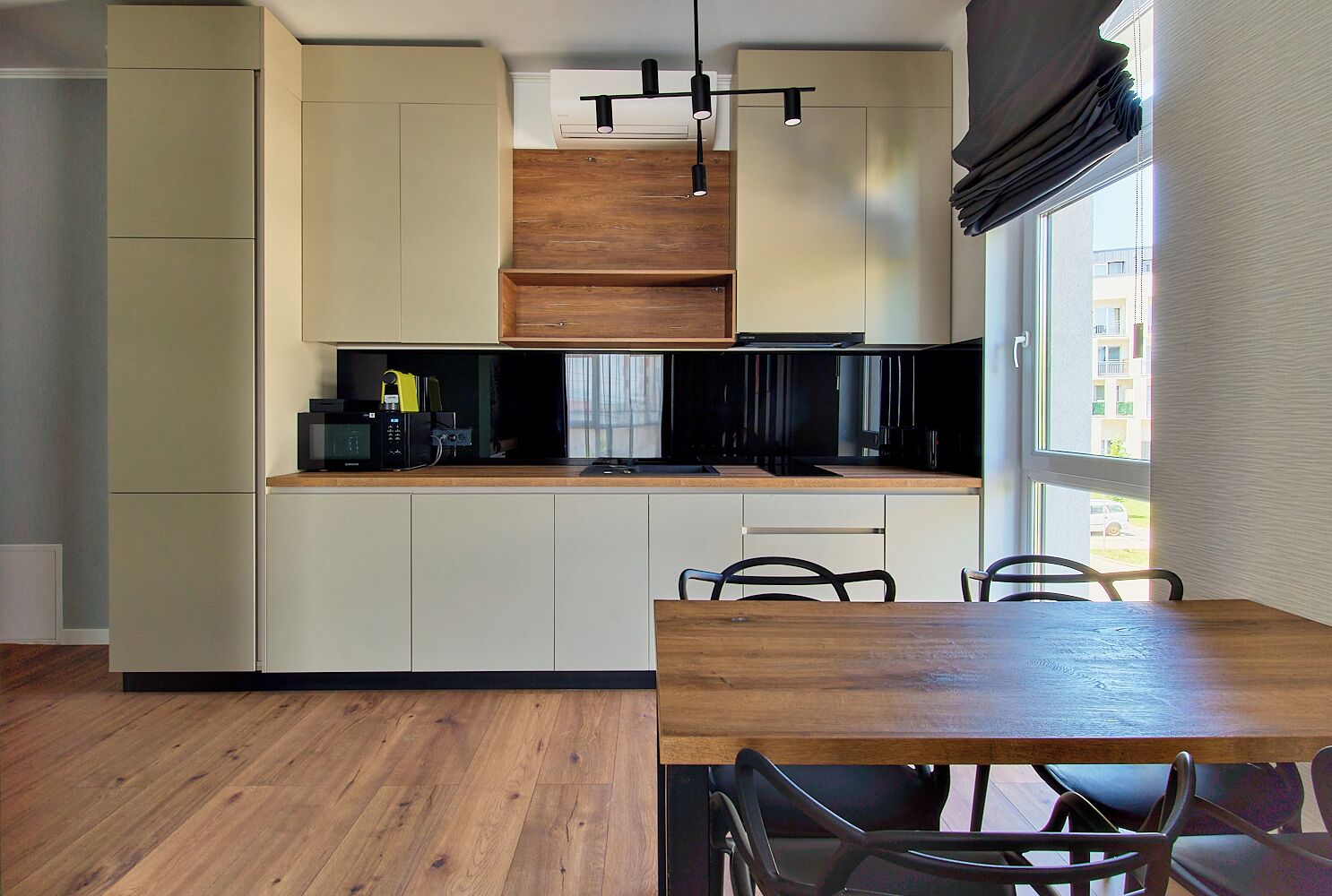 Una cocina moderna con electrodomésticos integrados, una mesa de comedor de madera y sillas.