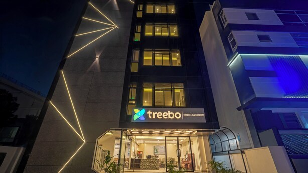 A modern hotel with a prominent 'treebo' sign, large windows, and geometric light patterns on the facade. - Treebo Premium Hydotel, Hi-Tech City (Hyderabad)