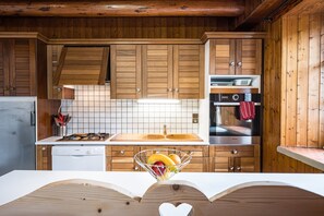 A kitchen with wooden cabinets, a white countertop, a stainless steel sink, and a dishwasher.