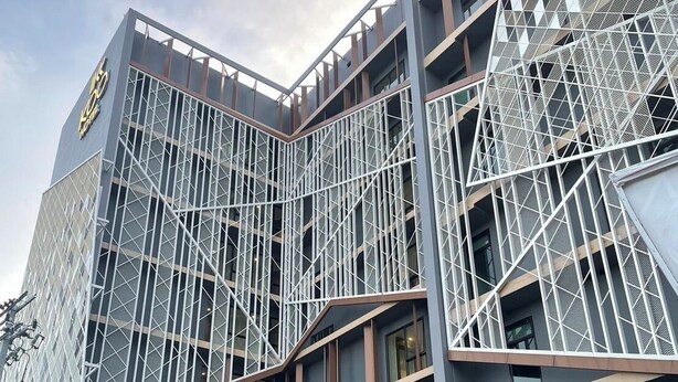 A modern hotel with a geometric facade, multiple balconies, and a prominent sign. - KOO Hotel (Pak Kret)