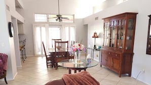 A spacious living room with a leather sofa, a dining area with a glass table, and a wooden cabinet. - Scottsdale Adobe Retreat with Private Pool & Hot Tub, King beds, Fast 5G Wifi. (Scottsdale)