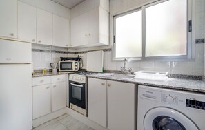 Een koelkast, een oven, een kookplaat, een koffiezetapparaat/waterkoker