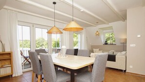 Un rincón comedor con una mesa, sillas, un sofá y una estantería.