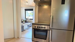 A modern kitchen with stainless steel appliances, including a built-in oven and a refrigerator.