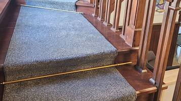 A staircase with wooden railings and carpeted steps.
