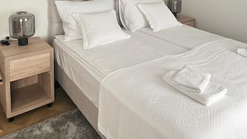 Un dormitorio con cama, mesitas de noche, un cuadro y una lámpara en el techo.