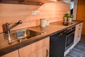 Een koelkast, een oven, een kookplaat, een vaatwasser