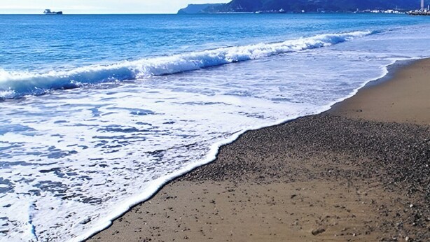 A beach with waves, pebbles, and a distant ship. - Raffaello Beach Apartment Savona, 50 m from the sea, WIFI, AC, equipped kitchen (Savona)