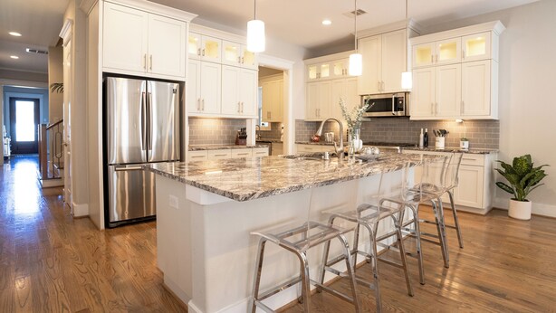 A modern kitchen with white cabinets, stainless steel appliances, and a marble island with bar stools. - Spacious 4-bedroom house Central Height Houston / w back yard & terrace (Houston)