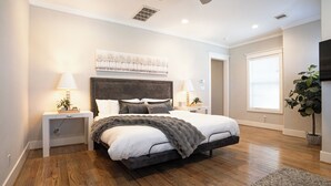 A bedroom with a bed, two bedside tables, a ceiling fan, a window with blinds, and a potted plant. - Spacious 4-bedroom house Central Height Houston / w back yard & terrace (Houston)