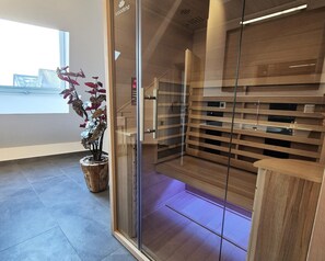 Ein modernes Interieur mit einer Glastrennwand, Holzregalen und einem Topfpflanzen.
