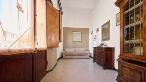 A hallway with a wooden cabinet, a beige sofa, and a wooden cabinet with glass doors.