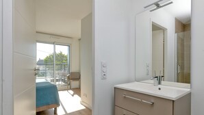 A modern bathroom with a large mirror, a sink, and a shower area. - Apartment 'Port Lin Near the Ocean' with Balcony and Wi-Fi (Le Croisic)