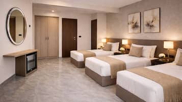 A hotel room with three beds, a TV, and artwork on the wall.
